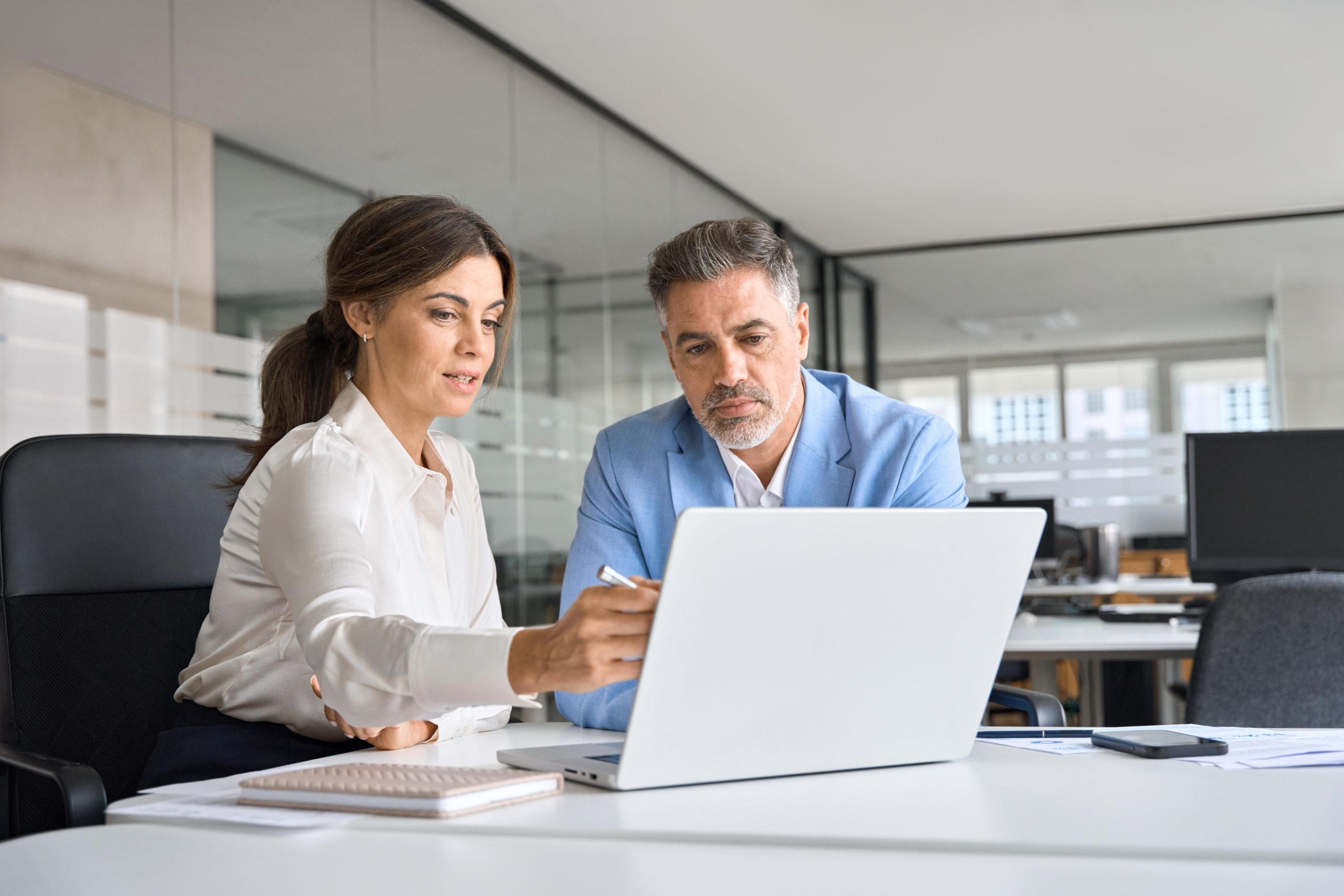 Two colleagues check a result on a laptop together